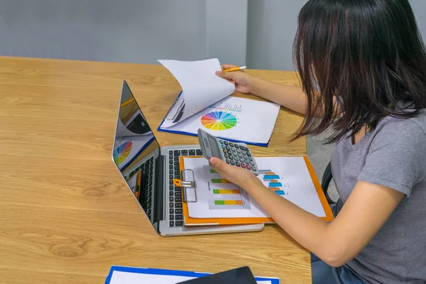 若いアジアの女性は計算機を保持し、レポートを読む — ストック写真