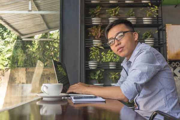 Freelancer asiático usando laptop en la cafetería — Foto de Stock