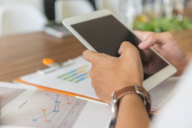 Ofisinde tablet kullanan bir adam.