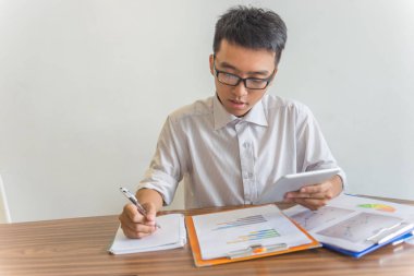 Tablet ve mali belge üzerinde çalışan işadamı