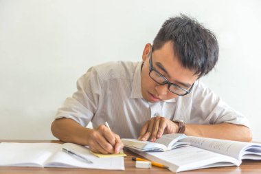 Kütüphanede ödev yapan Asyalı öğrenci