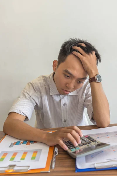 Азиатский мужчина обеспокоен финансовой проблемой в отчетах по продажам — стоковое фото