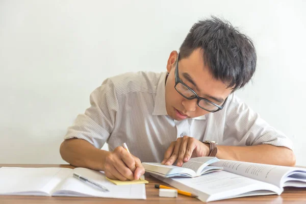 Estudante asiático fazendo lição de casa na biblioteca — Fotografia de Stock