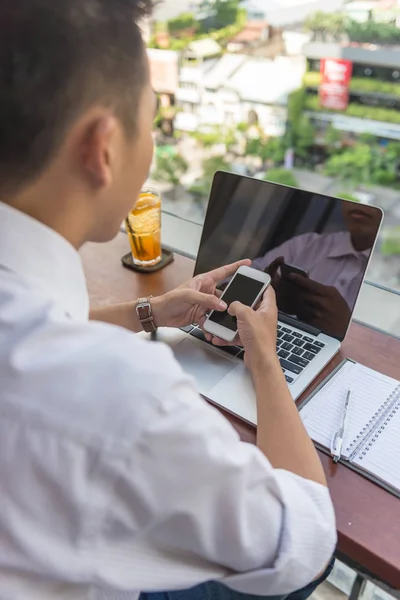 Foto vertical de un joven usando un teléfono inteligente — Foto de Stock