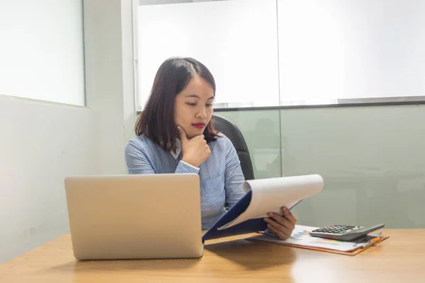 Gerente de oficina femenina leyendo informes de ventas y trabajando con computadora portátil — Foto de Stock