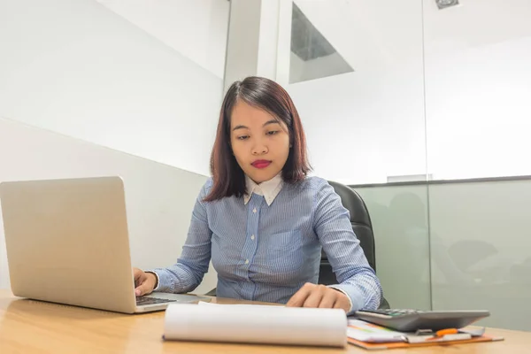 Gerente mujer leyendo informe financiero y trabajando en el ordenador portátil — Foto de Stock