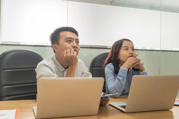 Jóvenes empleados asiáticos escuchando atentamente en la reunión — Foto de Stock
