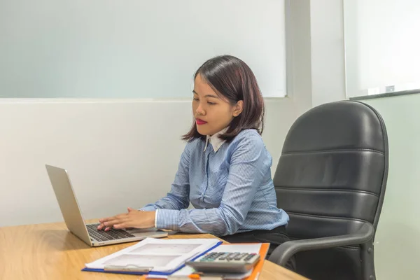 Empleado asiático trabajando en portátil con informes financieros — Foto de Stock