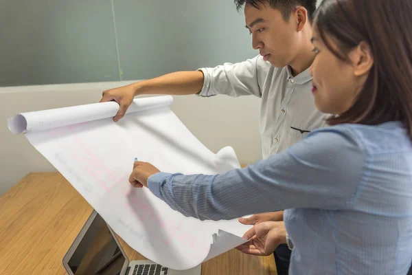 Asiatischer Geschäftsmann diskutiert mit Arbeitskollegen über Zeichnung — Stockfoto