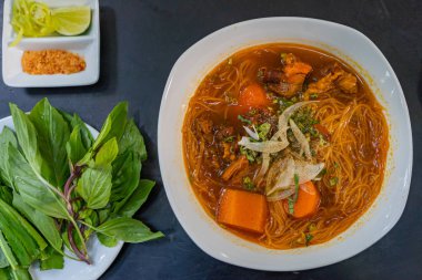 Vietnam usulü biftek buğulama, siyah arka planda pirinç eriştesi.