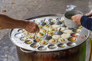 Tedarikçi Banh Khot- Vietnam aromalı karides krepi yapıyor.
