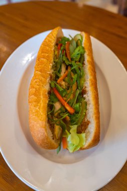 Vietnam usulü lezzetli tavuklu sandviç, beyaz tabakta.