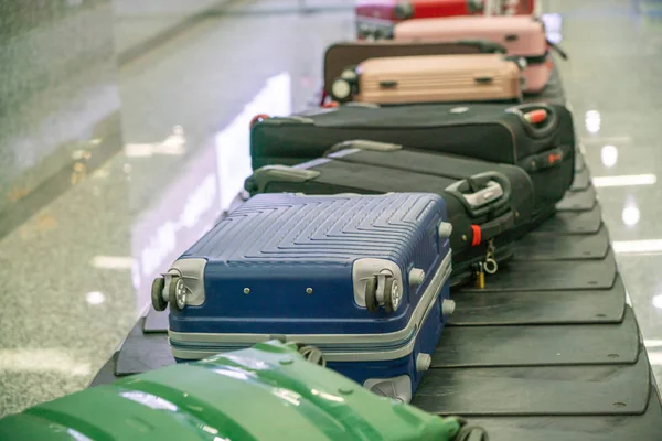 Maletas en la cinta transportadora de reclamo de equipaje en el aeropuerto — Foto de Stock