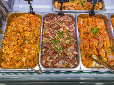 Süpermarkette satılık yiyecek tepsisinde marine edilmiş çiğ etler.