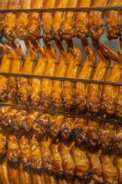 Lezzetli kızarmış tavuk kanatları metal şişler üzerinde