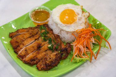 Lezzetli kızarmış tavuk pilavı, kızarmış yumurta ve turşuyla servis edilir.