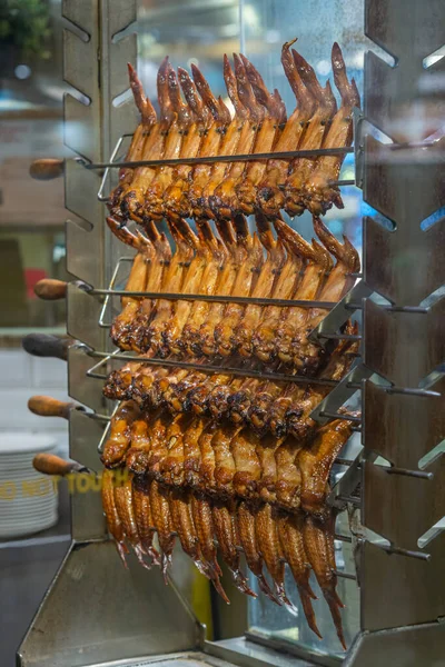 Rostade kycklingvingar hängande på grillmaskin på kinesisk restaurang — Stockfoto