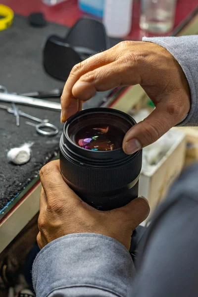 Technicus met geamputeerde vingerhouderij en reinigingscamera lens — Stockfoto