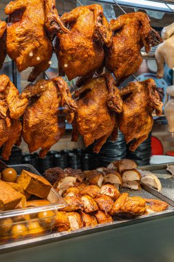 Çin restoranının vitrininde asılı kızarmış tavuklar.