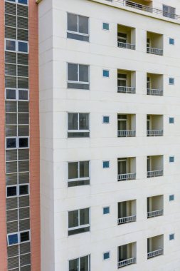 Pencereleri ve balkonları olan dış mimarisi olan bir apartman. 