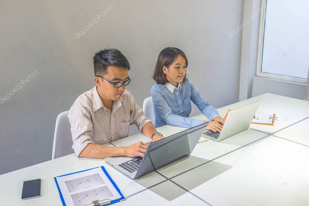 Young professional people working on laptop at business workplace