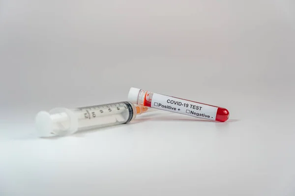 Infezione Covid-19 campione di esame del sangue e siringa su sfondo bianco — Foto Stock