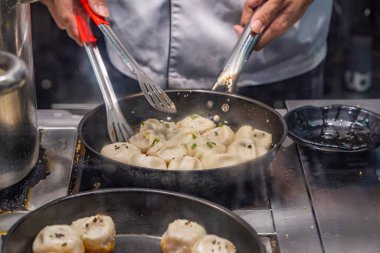 Şefin elleri tavada Çin usulü kızarmış köfte pişiriyor. 