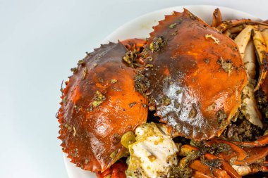 Sarımsaklı kızarmış yengeç ve beyaz tabakta tuz biberi.