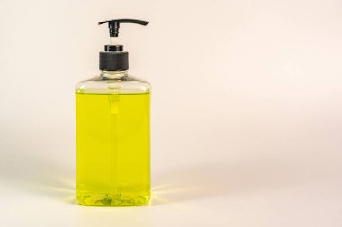 Beyaz arka planda bir şişe el dezenfektanı.