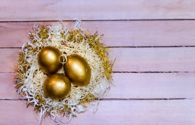 altın yumurta rustik ahşap arka plan ile saman yuvaya