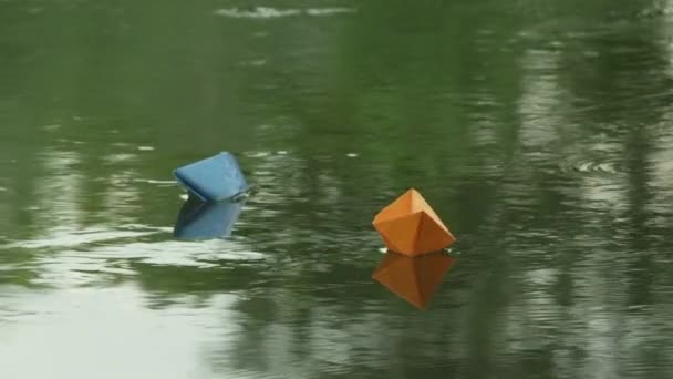 Две бумажные лодки плывут по течению реки — стоковое видео