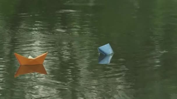 Две бумажные лодки плывут по течению реки — стоковое видео
