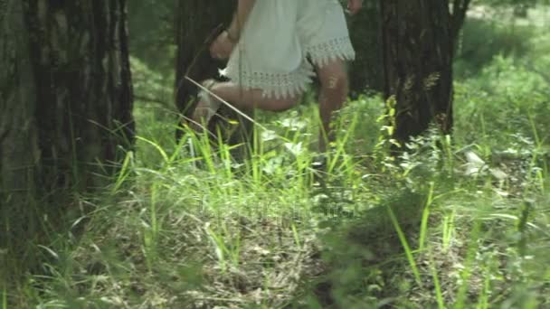 La chica corre hacia el bosque en la hierba — Vídeos de Stock