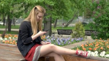 bir akıllı telefon kullanan sarışın kadın.