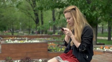 bir akıllı telefon kullanan sarışın kadın.