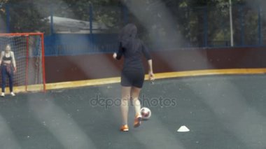 Kadın futbol oyuncusu topu atıyor 