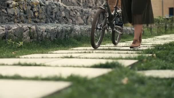 Kvinna gå bredvid ridning cykel — Stockvideo
