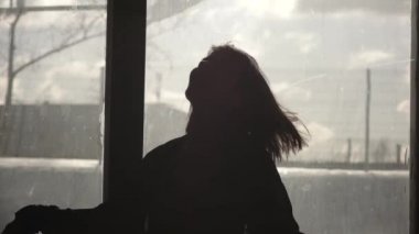 Bir pencere önünde dans mutlu bir kız silüeti