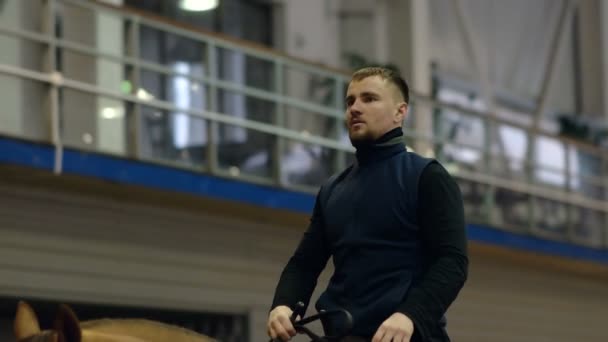 Un homme monté sur un cheval brun autour de l'arène. . Don race de cheval . — Video