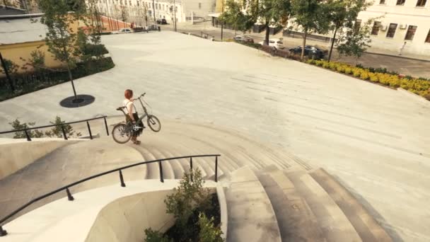 Jovem bicicleta mulher andando escadas abaixo e segurando suas mãos bicicleta — Vídeo de Stock