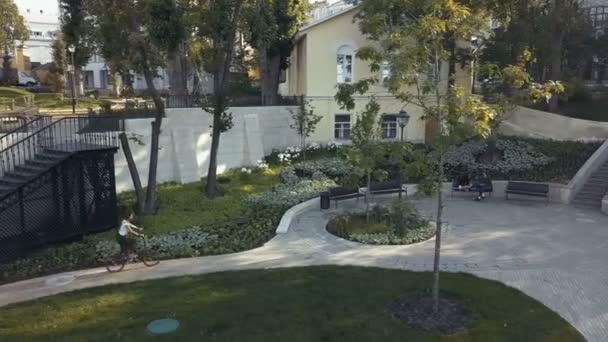 Redhaired woman cycling a bike on paved path in summer park. Woman bike park — Stock Video