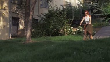 Bisiklet kadın Şehir Parkı içinde rampa sürme. Redhaired kadın bisikletçi bisiklet