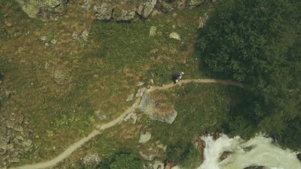 Vista dall'alto turista di montagna che cammina lungo il fiume rapido. Escursioni in montagna — Video Stock