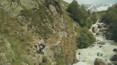Hızlı Nehri boyunca dağ izinde yürüyen turist adam.