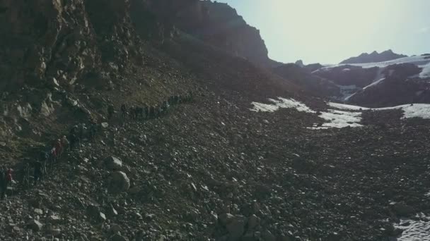 Drone vista grupo turístico senderismo valle de la montaña. Turistas en montaña sendero — Vídeos de Stock