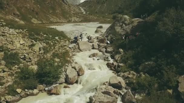 Grupo de turistas cruzando el río en la montaña. Vista aérea montaña río — Vídeos de Stock