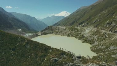 Dağ Manzaralı göl ve tepeler üzerinde yürüyen turist grubu. Dağ doğa