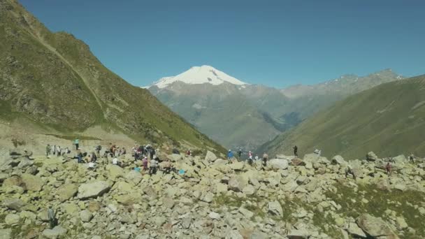 Letecký pohled na turistické skupiny stojící na horský hřeben na pozadí sněhu peak — Stock video