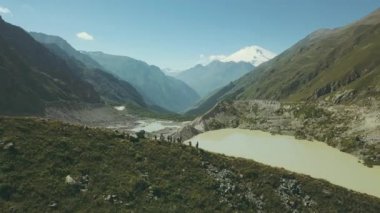 Arka plan dağ gölü kenarında dağ manzarasına turist grubu duruyor
