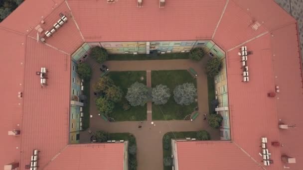 Aerial shooting from flying drone city building with red roof and colored walls — Stock Video